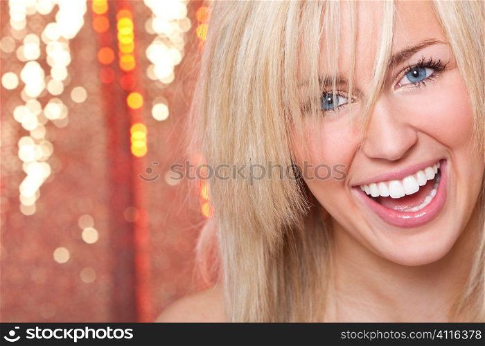 Studio shot of a stunningly beautiful young blonde woman shot with a sparkling red background