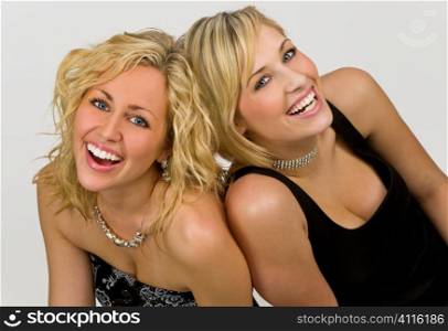 Studio shot of a two young beautiful young blond woman dressed upand having fun