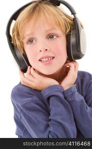 Studio shot of a young blond boy listening to music on headphones