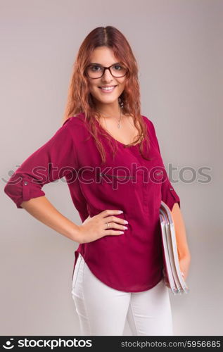 Studio shot of a young woman carrying some books