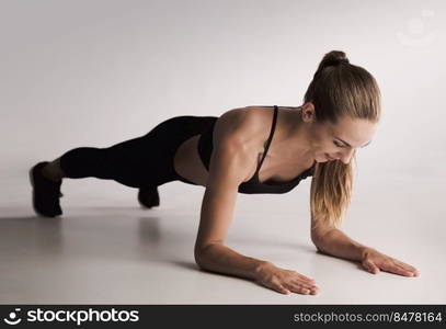 Studio shot of a young woman doing plank exercises