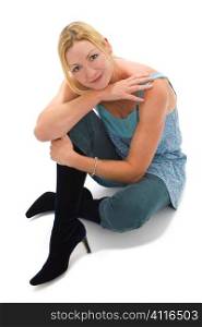 Studio shot of an attractive young woman in her thirties in a relaxed pose wearing long blue boots