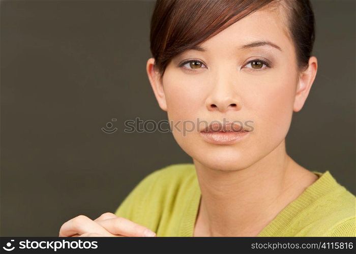 Studio shot of beautiful young oriental woman with a wonderful enigmatic smile