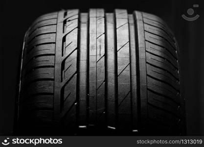 Studio shot of brand new car tire isolated on black background. close up.. Studio shot of brand new car tire isolated on black background. close up