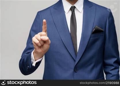 Studio shot of Businessman point finger at invisible screen, hand pushing touch screen, business man pressing digital virtual button isolated over grey background. Businessman point finger at invisible screen, hand pushing touch screen, business man pressing digital virtual button isolated over grey background