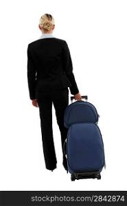studio shot of businesswoman pulling luggage