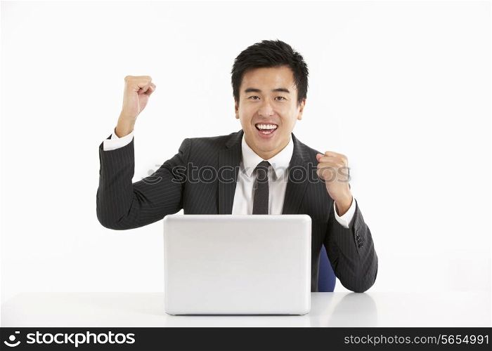 Studio Shot Of Chinese Businessman Working On Laptop And Celebrating