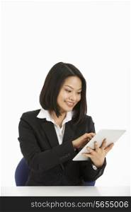 Studio Shot Of Chinese Businesswoman Working On Tablet Computer