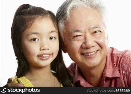 Studio Shot Of Chinese Grandfather With Granddaughter