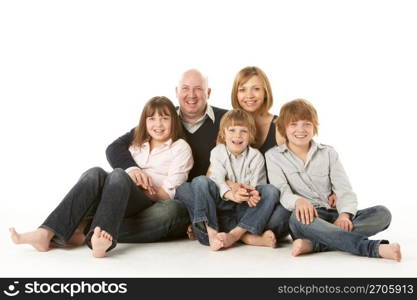 Studio Shot Of Family Group Sitting In Studio