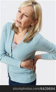 Studio Shot Of Mature Woman Suffering With Kidney Pain