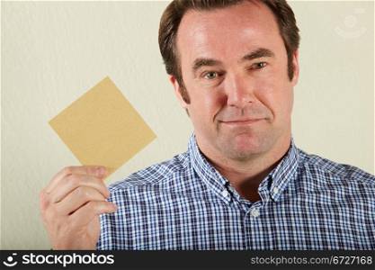 Studio Shot Of Middle Aged Man Holding Wage Packet