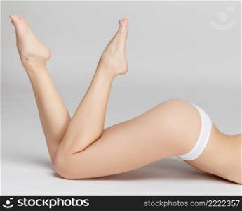 Studio shot of perfect female legs on grey background. Perfect female legs on grey background