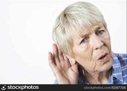 Studio Shot Of Senior Woman Suffering From Deafness