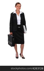 Studio shot of smiling woman in a suit with a briefcase