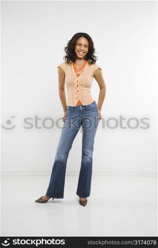 Studio shot of stylish multiethnic mid-adult woman smiling and looking at viewer.