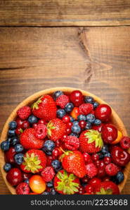 Studio shot of summer berries on wooden background. Fresh summer berries