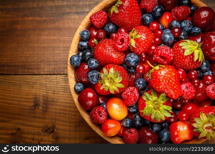 Studio shot of summer berries on wooden background. Fresh summer berries