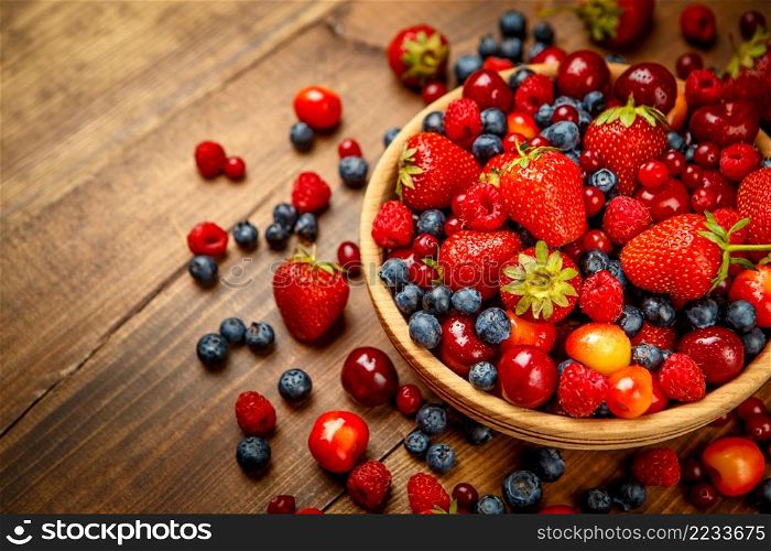 Studio shot of summer berries on wooden background. Fresh summer berries