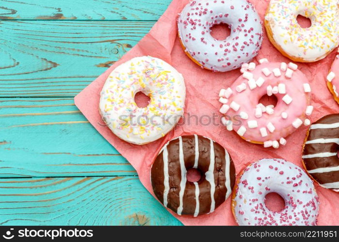 studio shot of tasty Donuts on colorful wooden background. Donuts on colorful wooden background