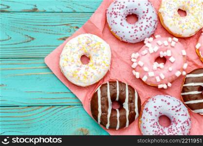 studio shot of tasty Donuts on colorful wooden background. Donuts on colorful wooden background