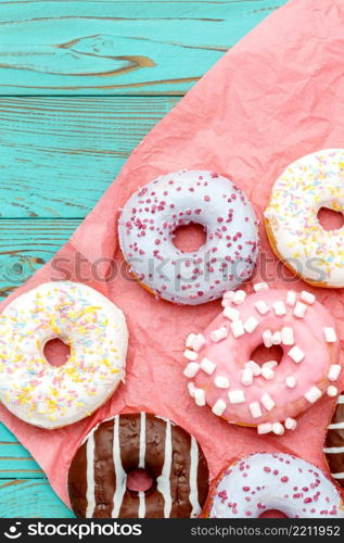 studio shot of tasty Donuts on colorful wooden background. Donuts on colorful wooden background