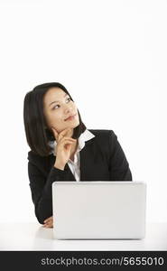 Studio Shot Of Thoughtful Chinese Businesswoman Working On Laptop