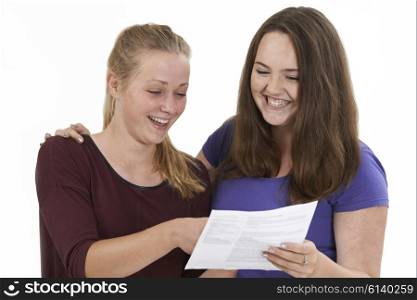 Studio Shot Of Two Female Teenage Friends Celebrating Exam Result