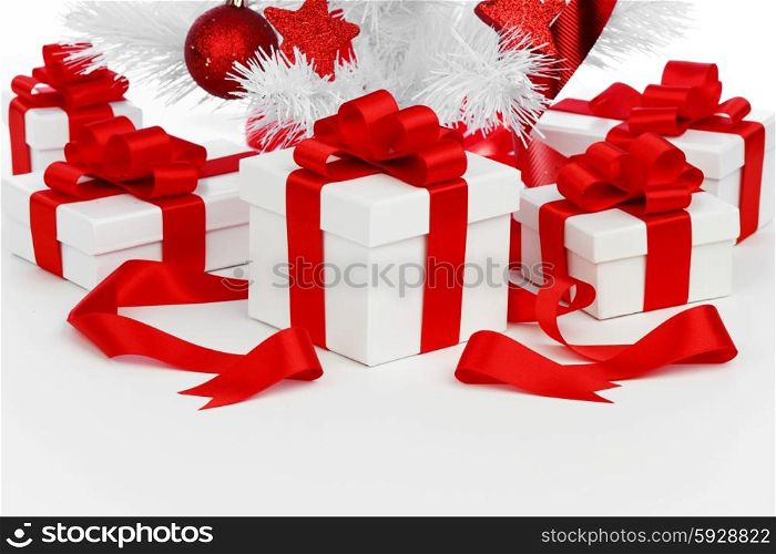 Studio shot of white gifts with red ribbons under Christmas tree, isolated on white