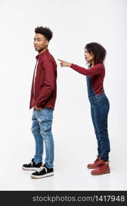 Studio shot of young angry woman pointing finger to her boyfriend with serious expression.. Studio shot of young angry woman pointing finger to her boyfriend with serious expression