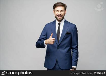Studio shot of young business man going thumb up on grey background. young business man going thumb up on grey background