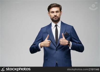 Studio shot of young business man going thumb up on grey background. young business man going thumb up on grey background