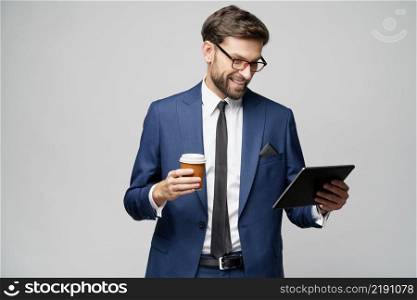 Studio shot of Young Businessman holding digital tablet pc pad and paper cup of coffee. Young Businessman holding digital tablet pc pad and paper cup of coffee