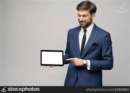 Studio shot of Young Businessman presenting digital tablet pc pad with blank screen. Young Businessman presenting digital tablet pc pad with blank screen