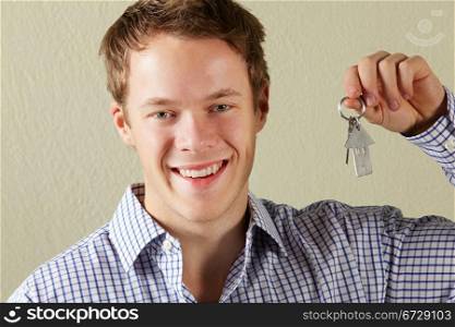 Studio Shot Of Young Man Holding Keys To First Home