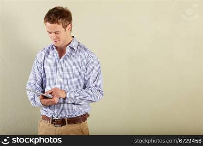 Studio Shot Of Young Man Using Tablet Computer