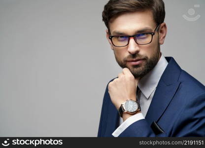 Studuo shot of thinking businessman wearing suit over grey background. Studuo shot of thinking businessman wearing suit