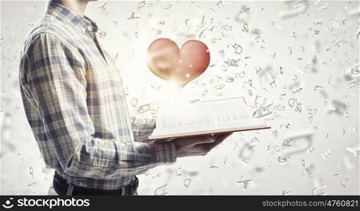 Study affair science. Young man with opened book and red heart on pages