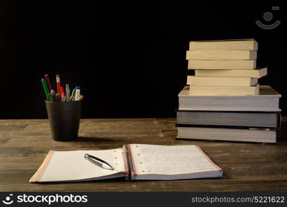 study table desk with books a open sketch book and pencil bucket, university study, school.