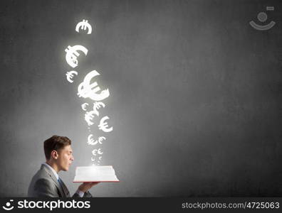 Study to be financial competent. Businessman with book and euro signs flying from pages