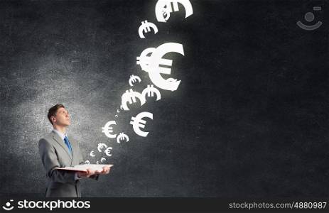 Study to be financial competent. Businessman with book and euro signs flying from pages