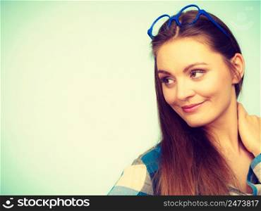 Studying, beauty of education and fun concept. Attractive nerdy woman in weird big glasses on head. Studio shot on blue background. Attractive nerdy woman in weird glasses on head