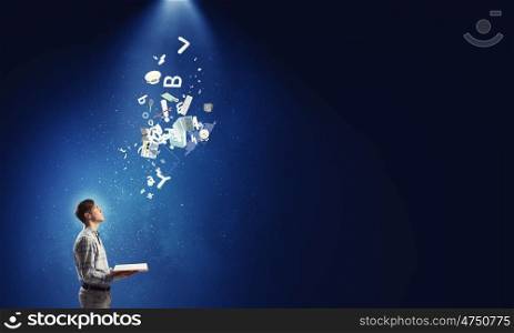 Studying media technologies. Young man with book in hands on digital background