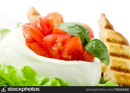 stuffed buffalo mozzarella with tomatoes and basil on lettuce over white isolated background