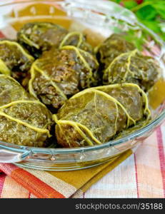 Stuffed cabbage with meat and rhubarb leaf in a glass pan on a background of a linen cloth