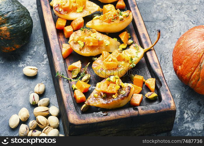 Stuffed pear pumpkin and pistachio.Autumn food.Baked pear dessert. Ripe baked pear with pumpkin