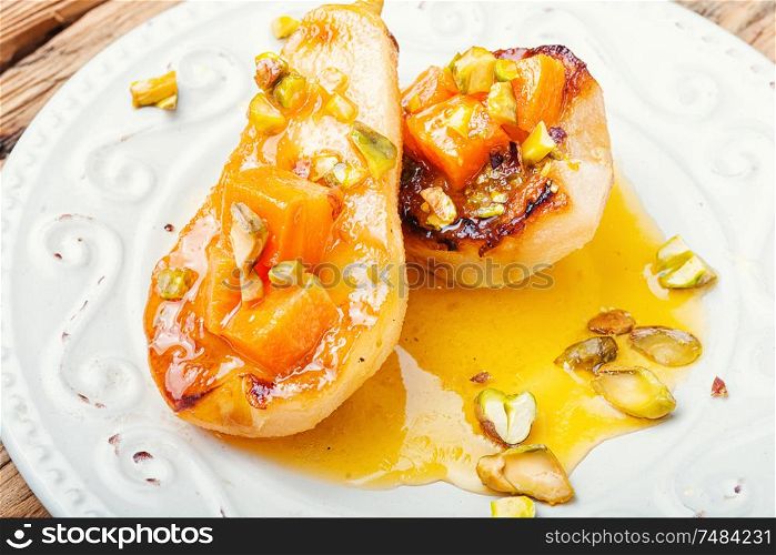 Stuffed pear pumpkin and pistachio.Baked pear.Caramelized pear with nuts. Ripe baked pear with pumpkin