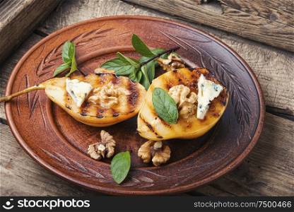 Stuffed pear with walnut and brie cheese.Baked pear.Caramelized pear with nuts. Sweet baked pears