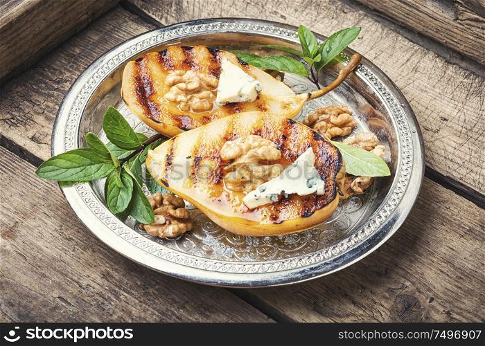 Stuffed pear with walnut and brie cheese.Homemade grill pears. Autumn or winter food. Grill pear with walnut