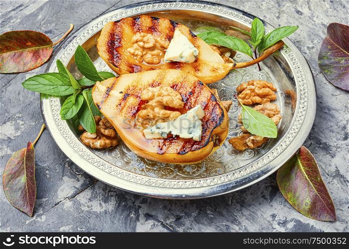 Stuffed pear with walnut and brie cheese.Homemade grill pears. Autumn or winter food. Grill pear with walnut